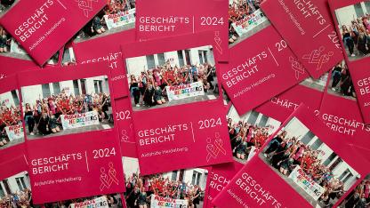 Foto: Viele Geschäftsberichte der Aidshilfe liegen auf und untereinander.