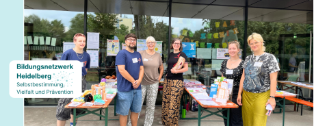 Gruppenfoto: Vertreter*innen des Bildungsnetzwerks vor ihrem Infostand