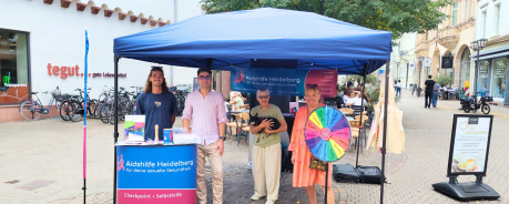 Infostand auf der Hauptstra&szlig;e mit 4 ehrenamtlichen Mitarbeitenden der Aidshilfe