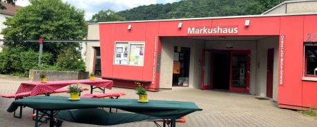 Hier ist die Front des Markushauses in der Südstadt zu sehen. Davor stehen schön gedeckte Bierbänke und -Tische.
