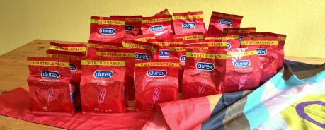 Auf einer Progress-Flag stehen viele Packungen voller Durex-Kondome. Die Packungen sind rot. Das Durex-Logo blau.