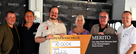 Gruppenfoto: Peter und Sigrid halten mit mehreren anderen Menschen einen großen Scheck für die Aidshilfe