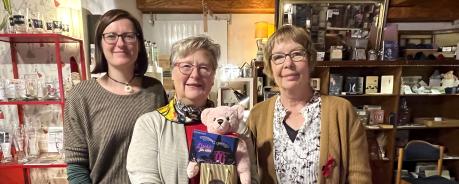 Spendenübergabe bei Frau Hönig in ihrem Laden in Ketsch: Juliane Schurig, Gabriele Hönig und Christine Klumb stehen gemeinsam vor Regalen, in denen Bücher und Dekoartikel stehen.