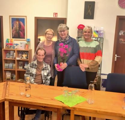 Die Vorstände Kalle Riegler, Christine Klumb, Anne Seyffert und Sigrid Zweygart-Pérez stehen zusammen. Anne Seyffert hält eine pinke Orchidee in der Hand.