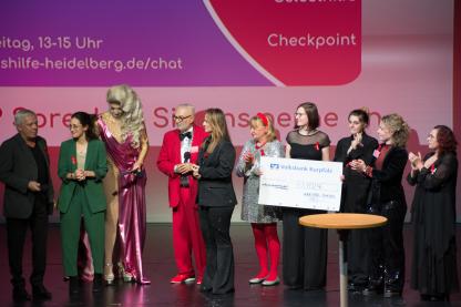 Gruppenbild: Unterstützer*innen und Mitarbeitende der Aidshilfe auf der Bühne der Sternengala