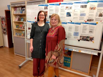 Juliane und Elke stehen vor einem Board mit einem Zeitstrahl zur Geschichte der HIV Epidemie und der Aidshilfe Heidelberg