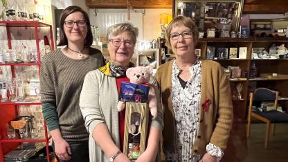 Spendenübergabe bei Frau Hönig in ihrem Laden in Ketsch: Juliane Schurig, Gabriele Hönig und Christine Klumb stehen gemeinsam vor Regalen, in denen Bücher und Dekoartikel stehen.