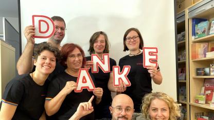Die hauptamtlichen Mitarbeitenden mit ihren neuen T-Shirts. Sie halten Buchstaben, die zusammen das Wort: „Danke“ ergeben.