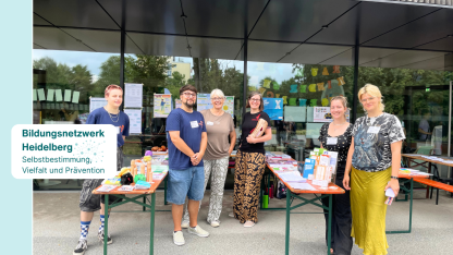 Gruppenfoto: Vertreter*innen des Bildungsnetzwerks vor ihrem Infostand