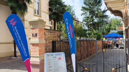 Foto der Aidshilfe: Vor dem Eingang zum Hinterhof sind Beachflags mit Logos der Aidshilfe 