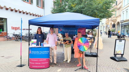 Infostand auf der Hauptstra&szlig;e mit 4 ehrenamtlichen Mitarbeitenden der Aidshilfe