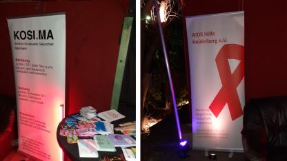 Banner von der AIDS-Hilfe Heidelberg und KOSI.MA. Auf einem Stehtisch liegen verschiedene Materialien.