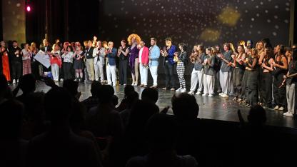Gruppenbild: Alle Acts und Ehrenamtlichen stehen auf der Bühne des Theaters
